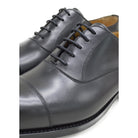 A Berwick 1707 black leather Oxford shoe with a chisel toe and lace-up closure with a Dainite rubber studded sole, on a white background.