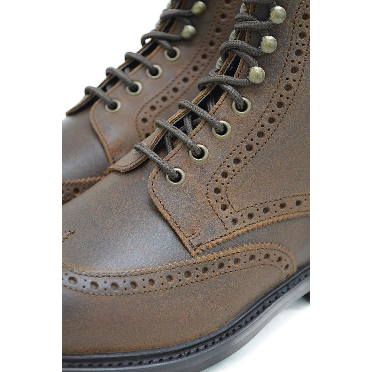 A dark brown lace-up brogue boot with a rubber sole and visible stitching on the upper part.