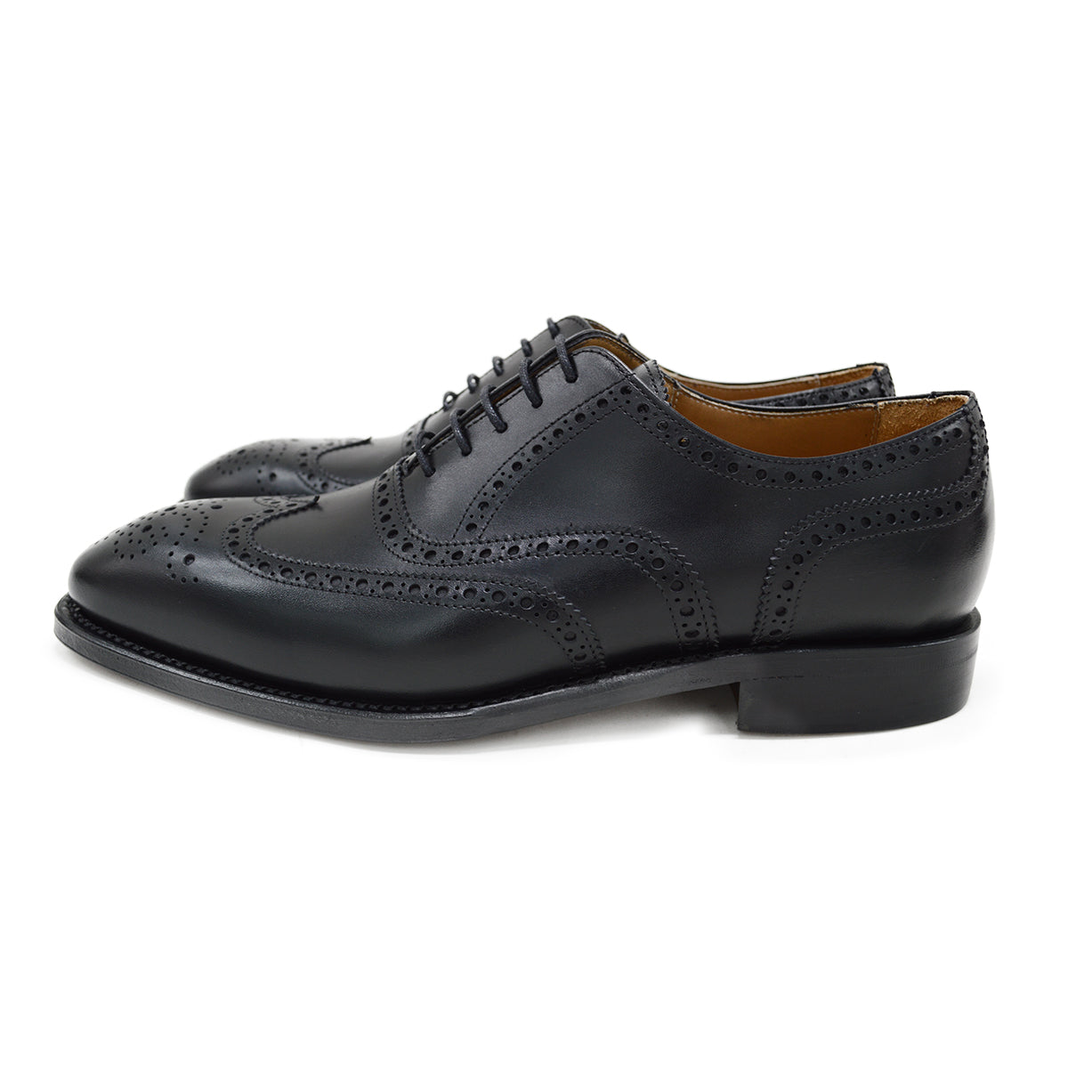 A Berwick 1707 black Oxford brogue shoe with brogue detailing and a lace-up closure. The shoe is made of smooth leather and appears to be sturdy and durable.