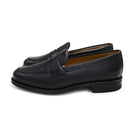 A black deerskin Penny loafer with a velvety soft texture and a classic round toe & Dainite sole, set against a white background.