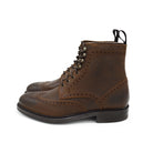 A dark brown lace-up brogue boot with a rubber sole and visible stitching on the upper part.