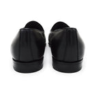 A black deerskin leather tassel Belgian loafer with an almond-shaped toe and a subtle tread sole, displayed against a white background.