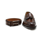 A Berwick 1707 brown calf leather belt with a silver chrome buckle, displayed on a white background with the same colour Berwick 1707 tasselled loafer