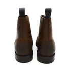 A dark brown lace-up brogue boot with a rubber sole and visible stitching on the upper part.