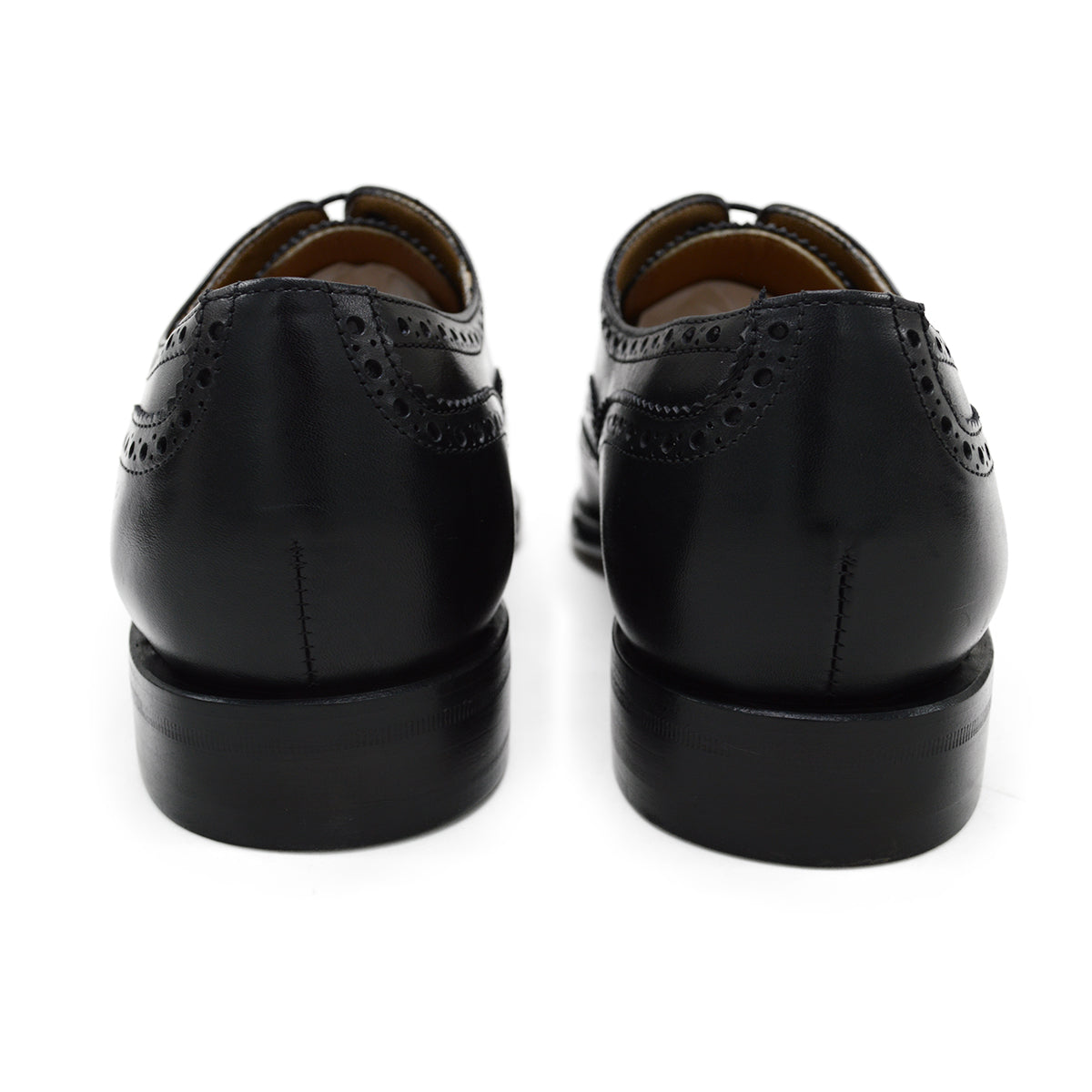 A Berwick 1707 black Oxford brogue shoe with brogue detailing and a lace-up closure. The shoe is made of smooth leather and appears to be sturdy and durable.