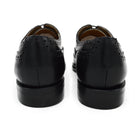 A Berwick 1707 black Oxford brogue shoe with brogue detailing and a lace-up closure. The shoe is made of smooth leather and appears to be sturdy and durable.