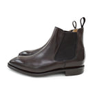 A dark brown leather Chelsea boot with a side pull tab and a low heel & Dainite soles, displayed on a white background.