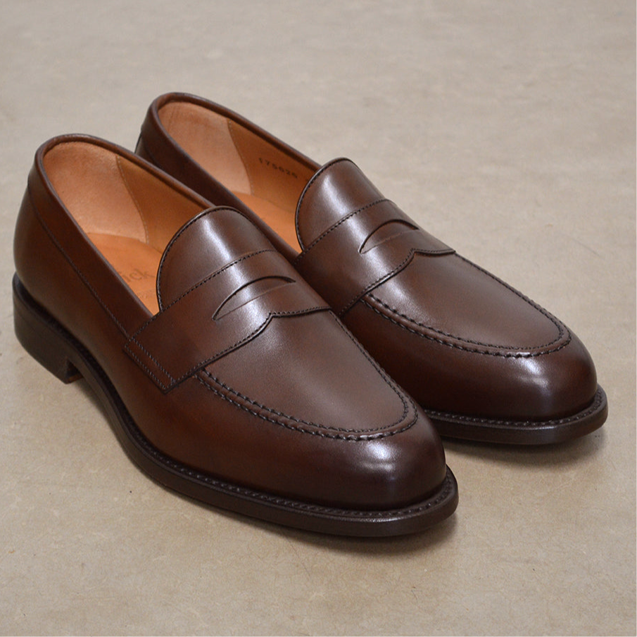 Berwick 1707 Brown leather loafer shoe on a polished concrete background 