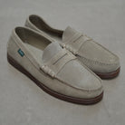 Pair of beige loafers on a gray background