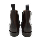 A dark brown leather Chelsea boot with a side pull tab and a low heel & Dainite soles, displayed on a white background.