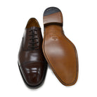 A Berwick 1707 dark brown, chisel toe Oxford shoe with a lace-up closure and a single leather sole.