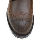 A dark brown lace-up brogue boot with a rubber sole and visible stitching on the upper part.