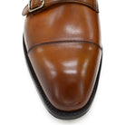 A brown double monk strap shoe with a polished leather upper and a Goodyear welted sole.