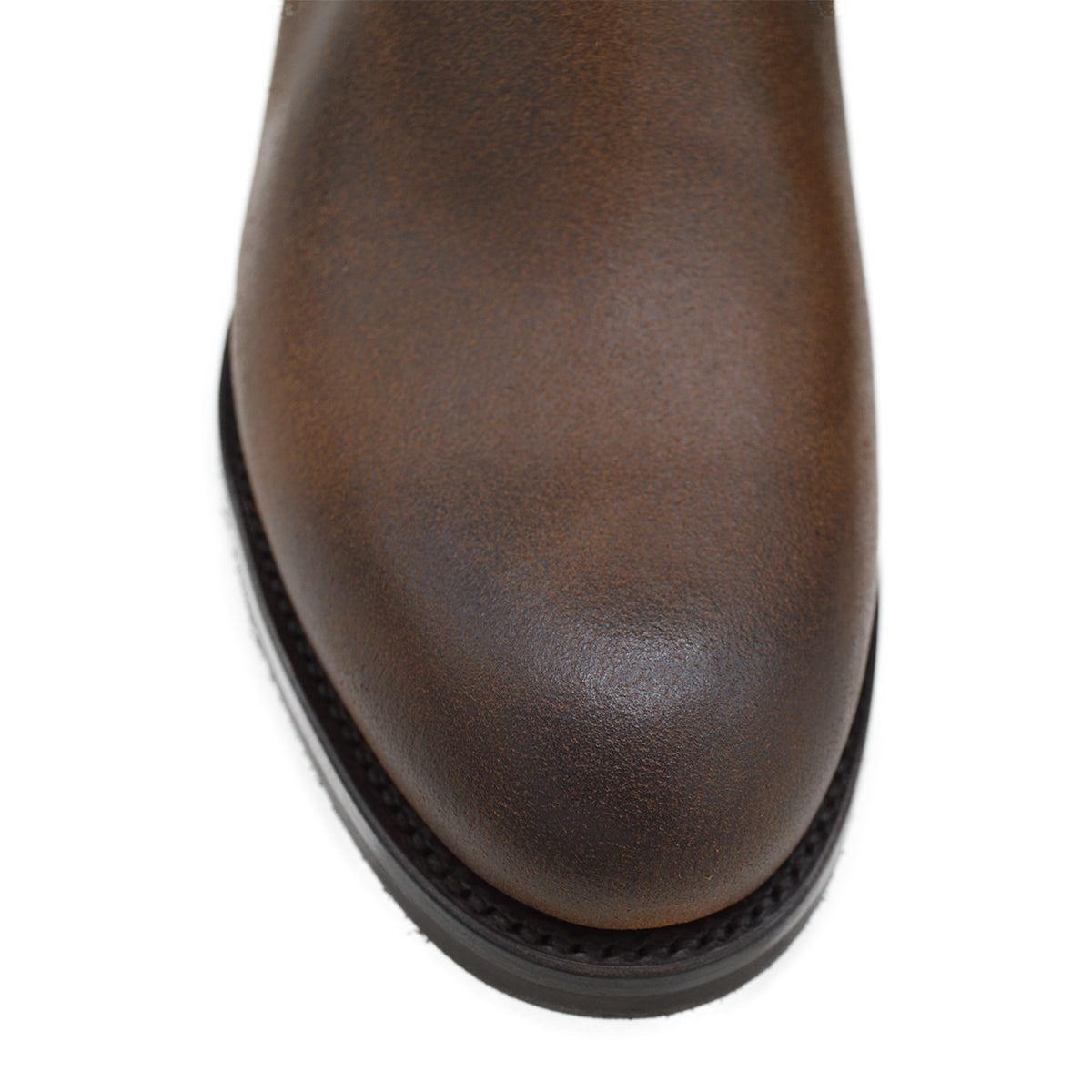 A dark brown Chelsea boot with a waxy leather finish and a contrasting black elastic side panel. The boot has a low heel and a small pull tab at the rear.