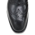 A Berwick 1707 black Oxford brogue shoe with brogue detailing and a lace-up closure. The shoe is made of smooth leather and appears to be sturdy and durable.