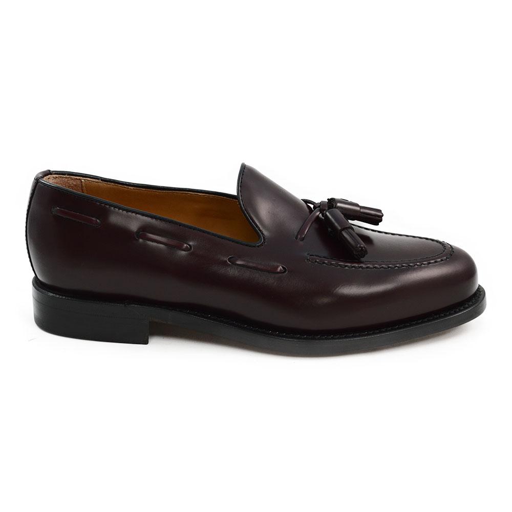 A Berwick 1707 burgundy hi shine leather slip-on shoe with a tassel detail on the vamp, set against a white background.