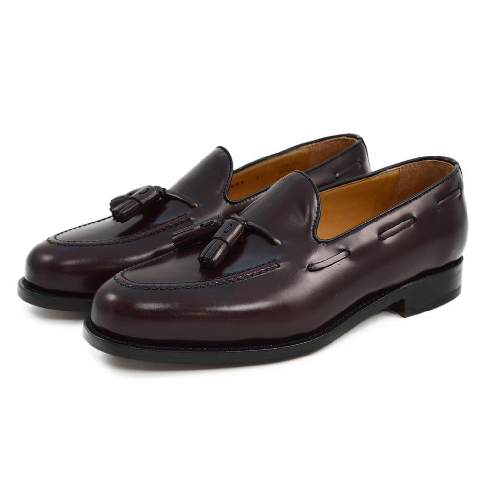 A Berwick 1707 burgundy hi shine leather slip-on shoe with a tassel detail on the vamp, set against a white background.