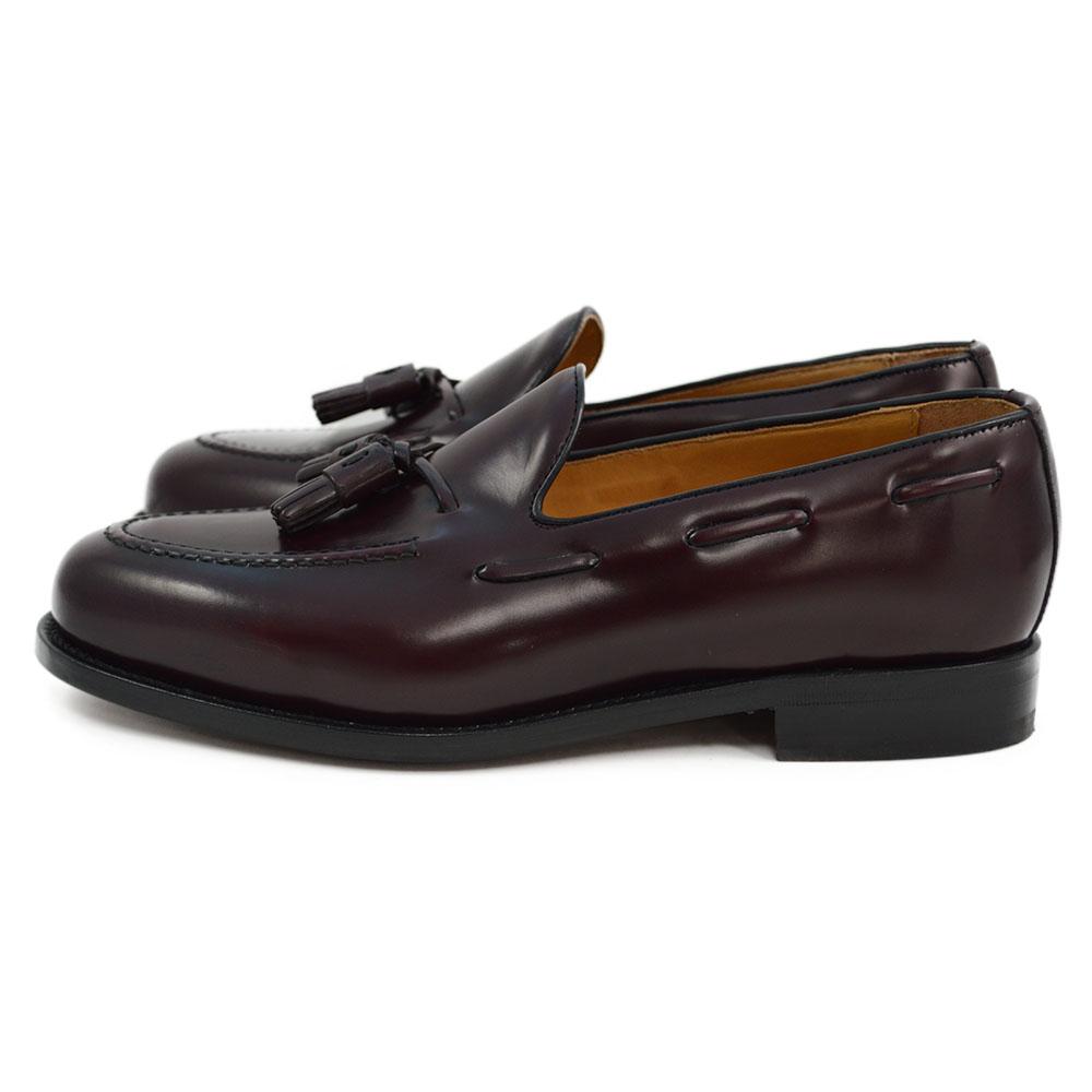 A Berwick 1707 burgundy hi shine leather slip-on shoe with a tassel detail on the vamp, set against a white background.