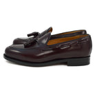A Berwick 1707 burgundy hi shine leather slip-on shoe with a tassel detail on the vamp, set against a white background.