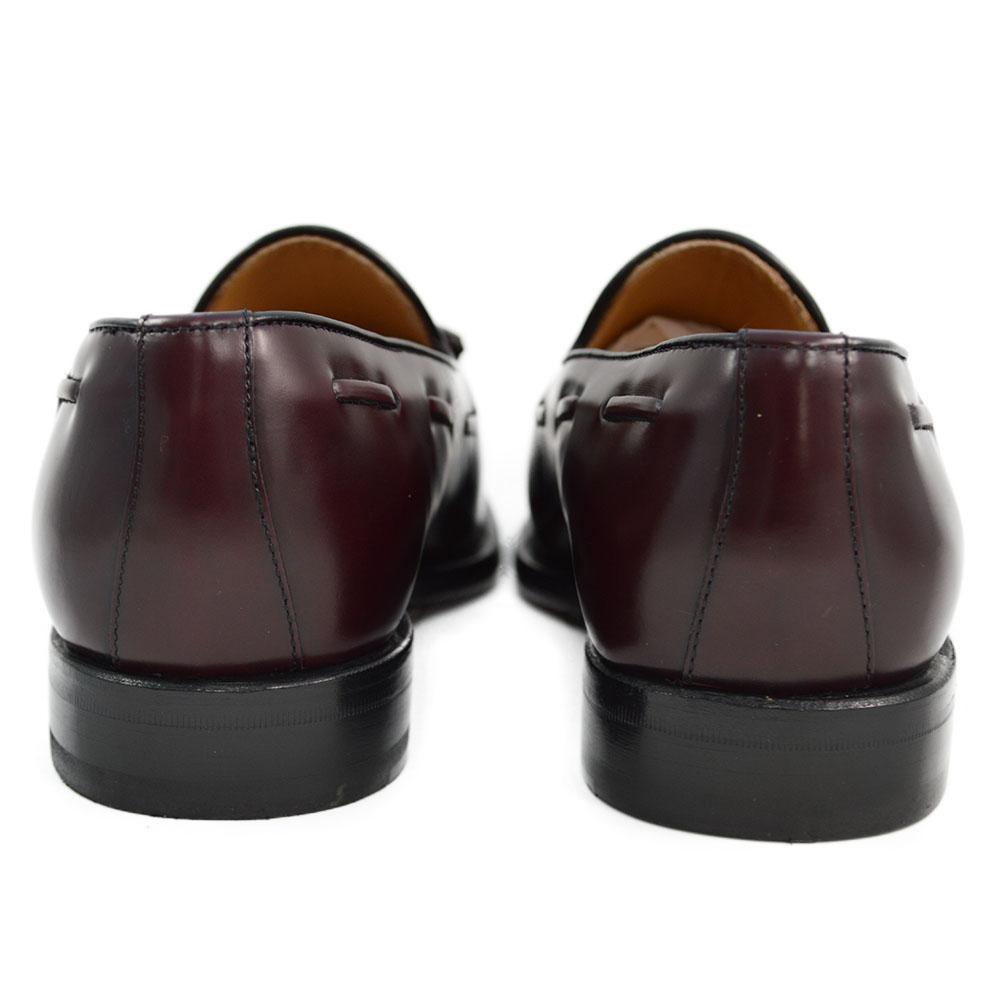 A Berwick 1707 burgundy hi shine leather slip-on shoe with a tassel detail on the vamp, set against a white background.