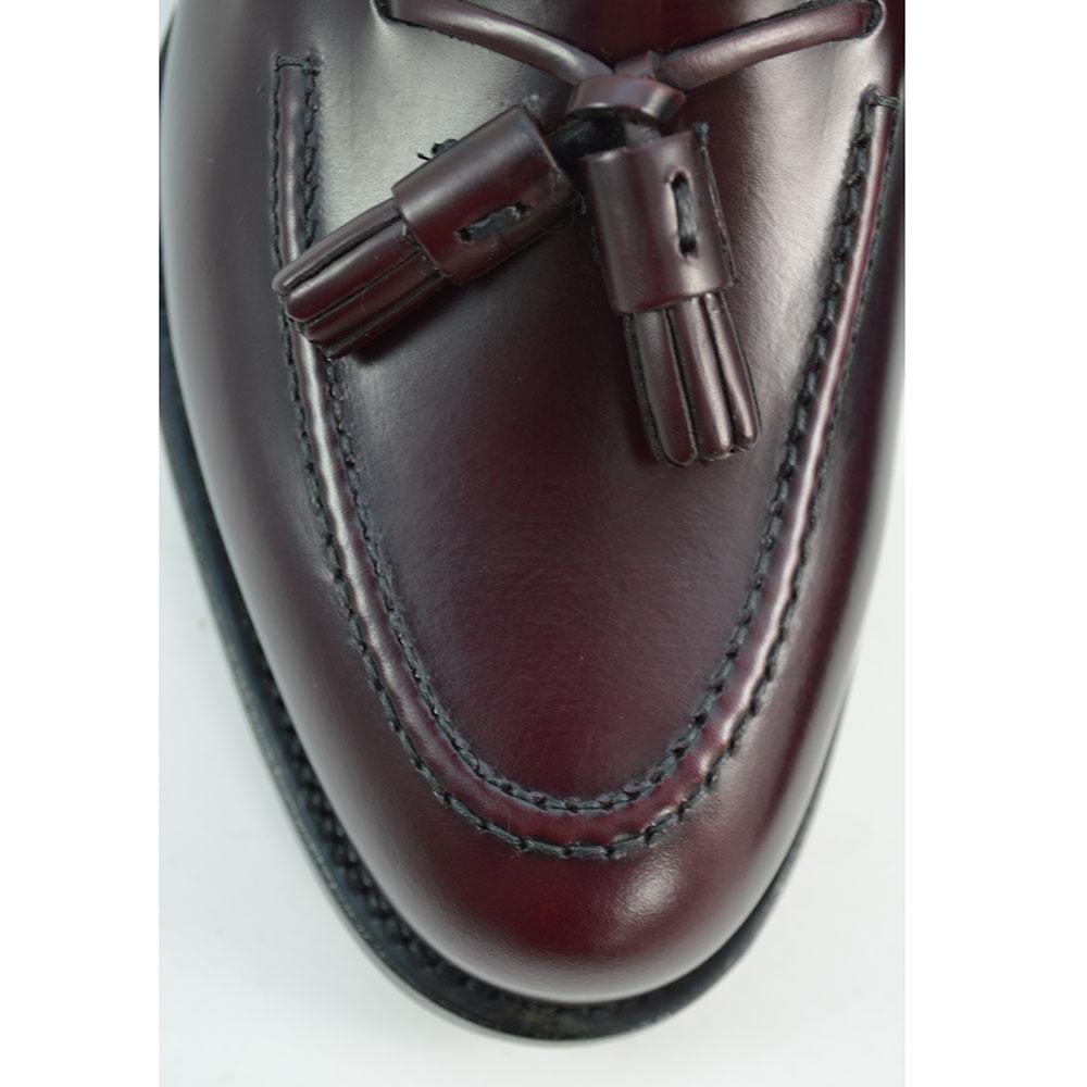 A Berwick 1707 burgundy hi shine leather slip-on shoe with a tassel detail on the vamp, set against a white background.