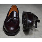 A Berwick 1707 dark brown tasselled slip-on shoe with a polished, smooth upper and a Dainite rubber sole.