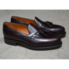 A Berwick 1707 dark brown tasselled slip-on shoe with a polished, smooth upper and a Dainite rubber sole.