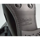 A Berwick 1707 dark brown tasselled slip-on shoe with a polished, smooth upper and a Dainite rubber sole.