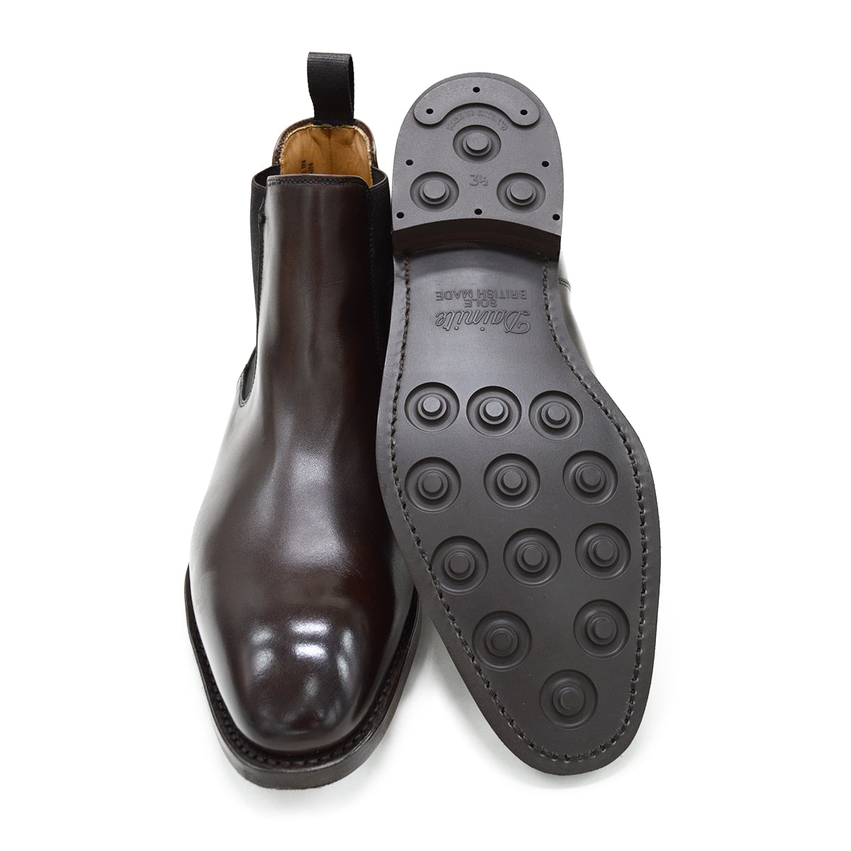 A dark brown leather Chelsea boot with a side pull tab and a low heel & Dainite soles, displayed on a white background.