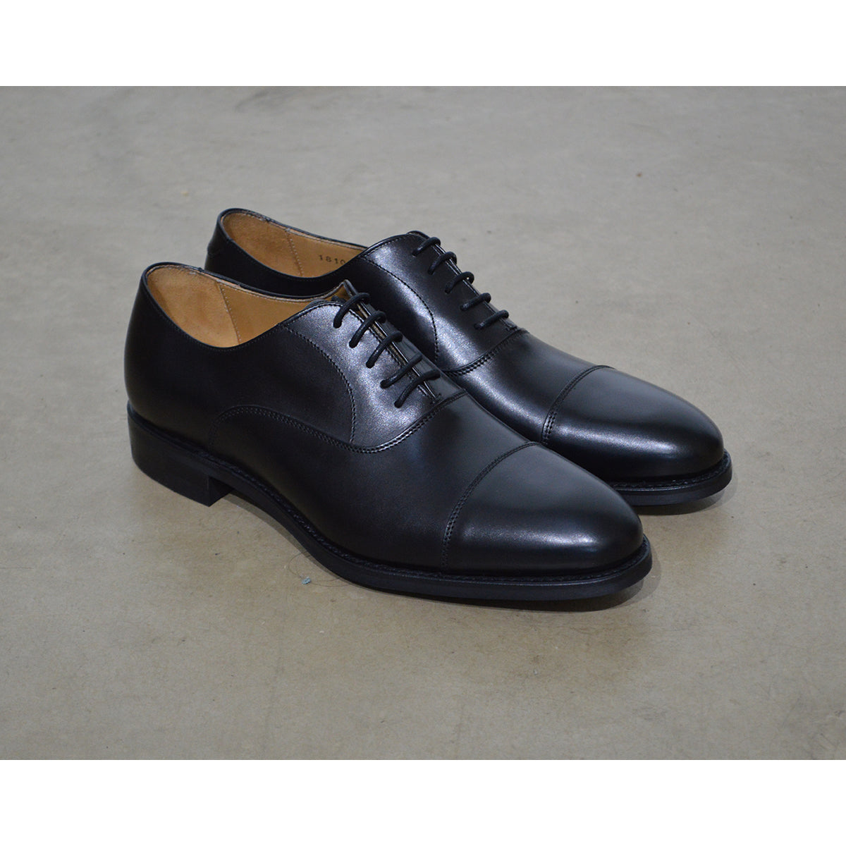 A Berwick 1707 black Oxford shoe with a polished, smooth upper and a Dainite rubber sole.