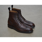A Berwick 1707 dark brown brogue boot with a lace-up closure, round toe shape, and a Dainite rubber sole.