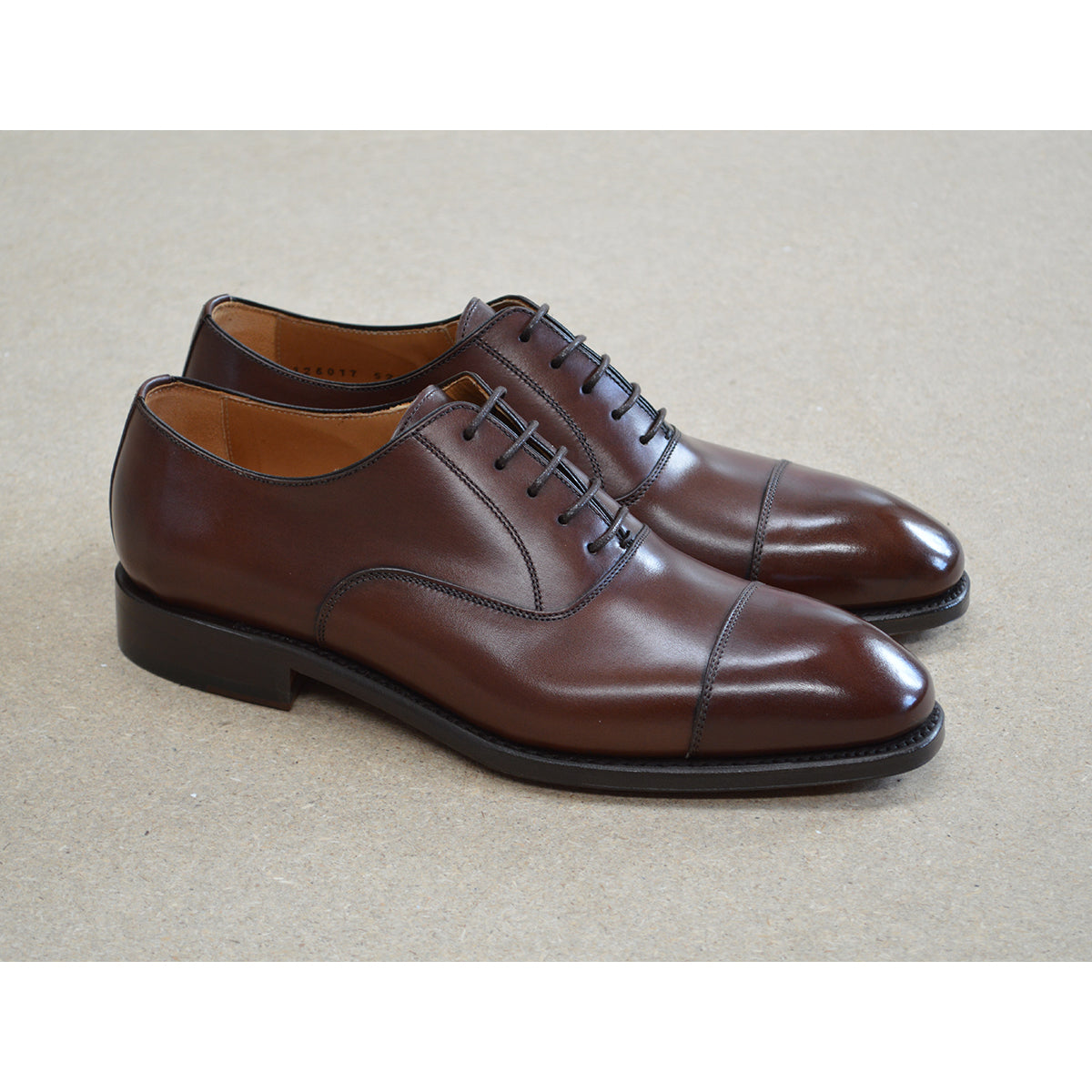 A Berwick 1707 dark brown, chisel toe Oxford shoe with a lace-up closure and a single leather sole.