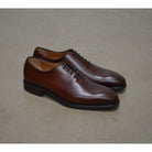 A Berwick 1707 brown leather wholecut oxford shoe with a lace-up closure and a round toe.