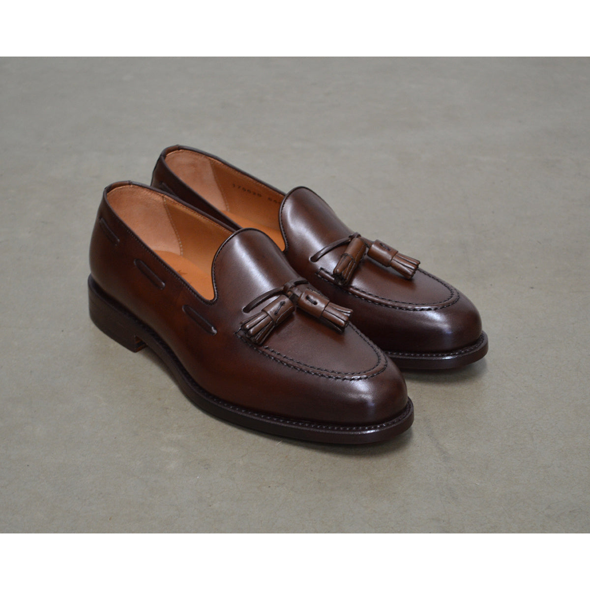 A Berwick 1707 brown tasseled loafer shoe with a closed toe and leather sole.