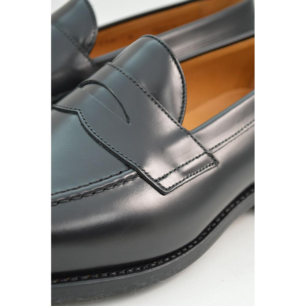 A black high-shine Berwick 1707 Penny Loafer with a round toe and Dainite rubber sole.