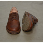 A dark chestnut brown Astorflex Redflex derby shoe made of nubuck leather, featuring a natural crepe rubber sole.