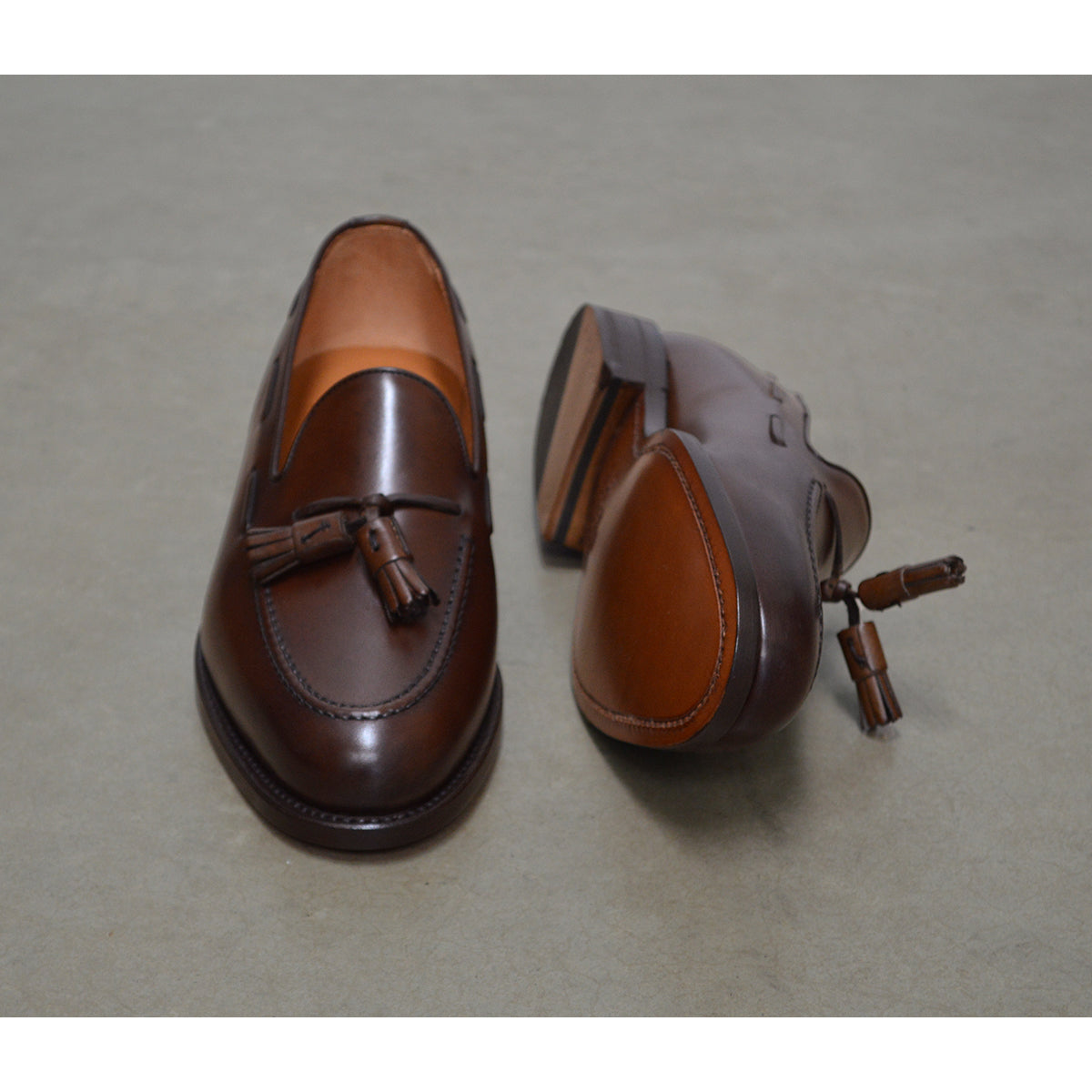 A Berwick 1707 brown tasseled loafer shoe with a closed toe and leather sole.