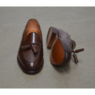 A Berwick 1707 brown tasseled loafer shoe with a closed toe and leather sole.