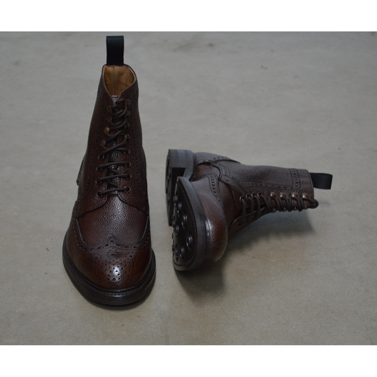 A Berwick 1707 dark brown brogue boot with a lace-up closure, round toe shape, and a Dainite rubber sole.