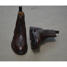 A Berwick 1707 dark brown brogue boot with a lace-up closure, round toe shape, and a Dainite rubber sole.