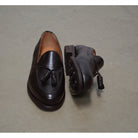 A Berwick 1707 dark brown deerskin slip-on loafer with a tassel detail on the vamp & Dainite sole