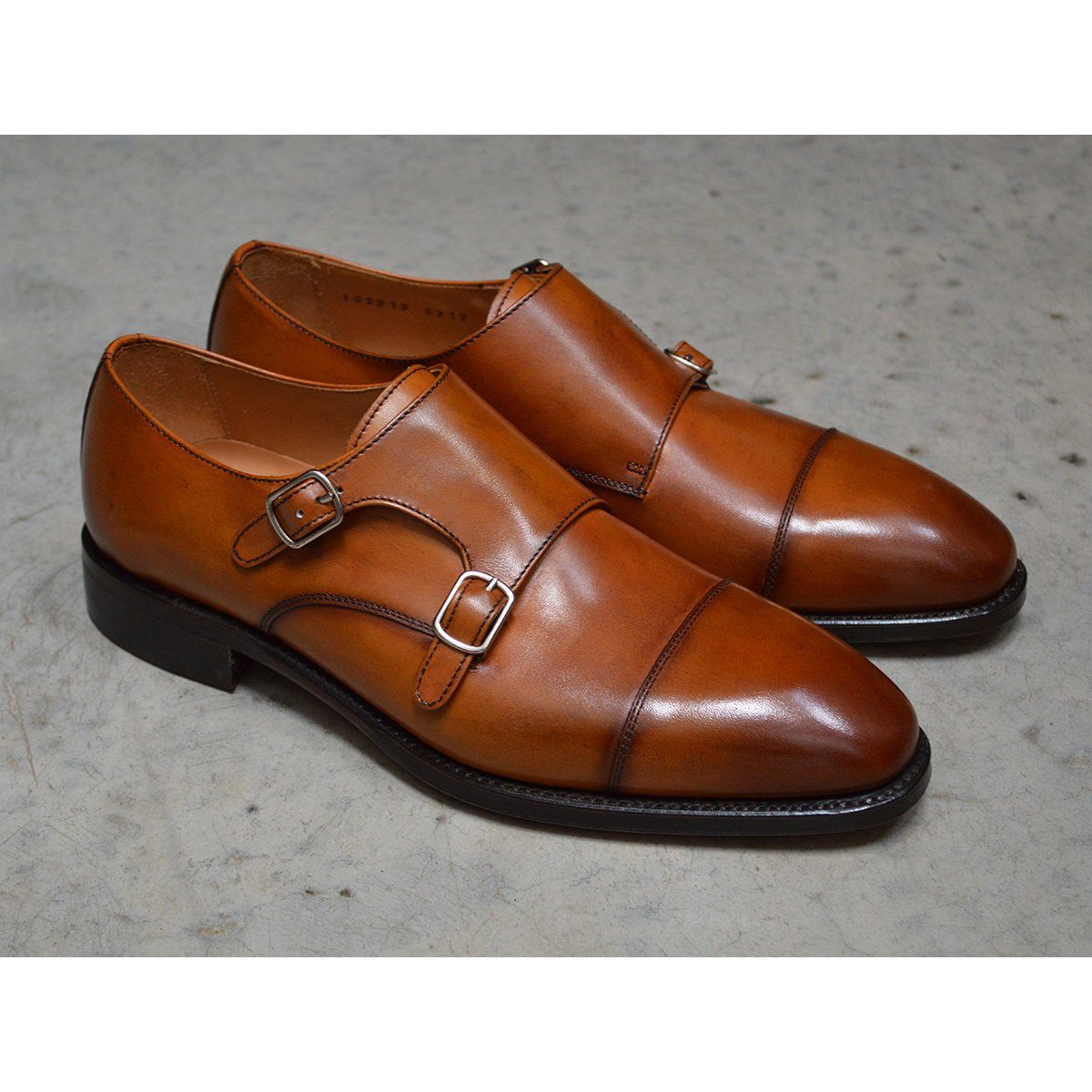 A brown double monk strap shoe with a polished leather upper and a Goodyear welted sole.