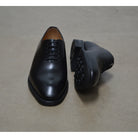 A black Berwick 1707 Wholecut Oxford shoe made from box calf leather with a lace-up closure and a round toe.