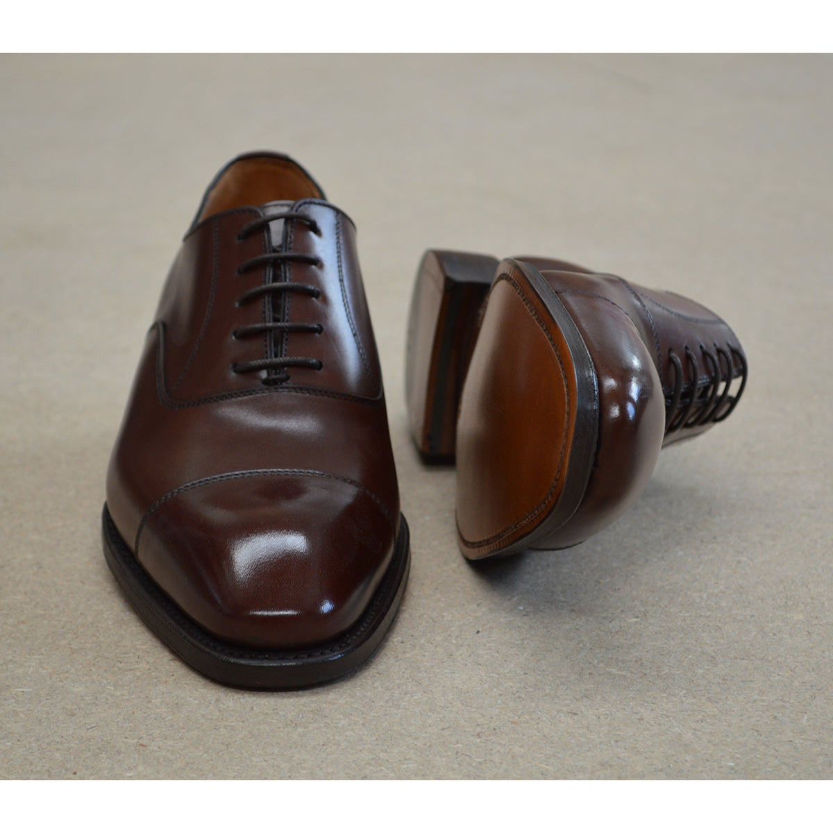 A Berwick 1707 dark brown, chisel toe Oxford shoe with a lace-up closure and a single leather sole.