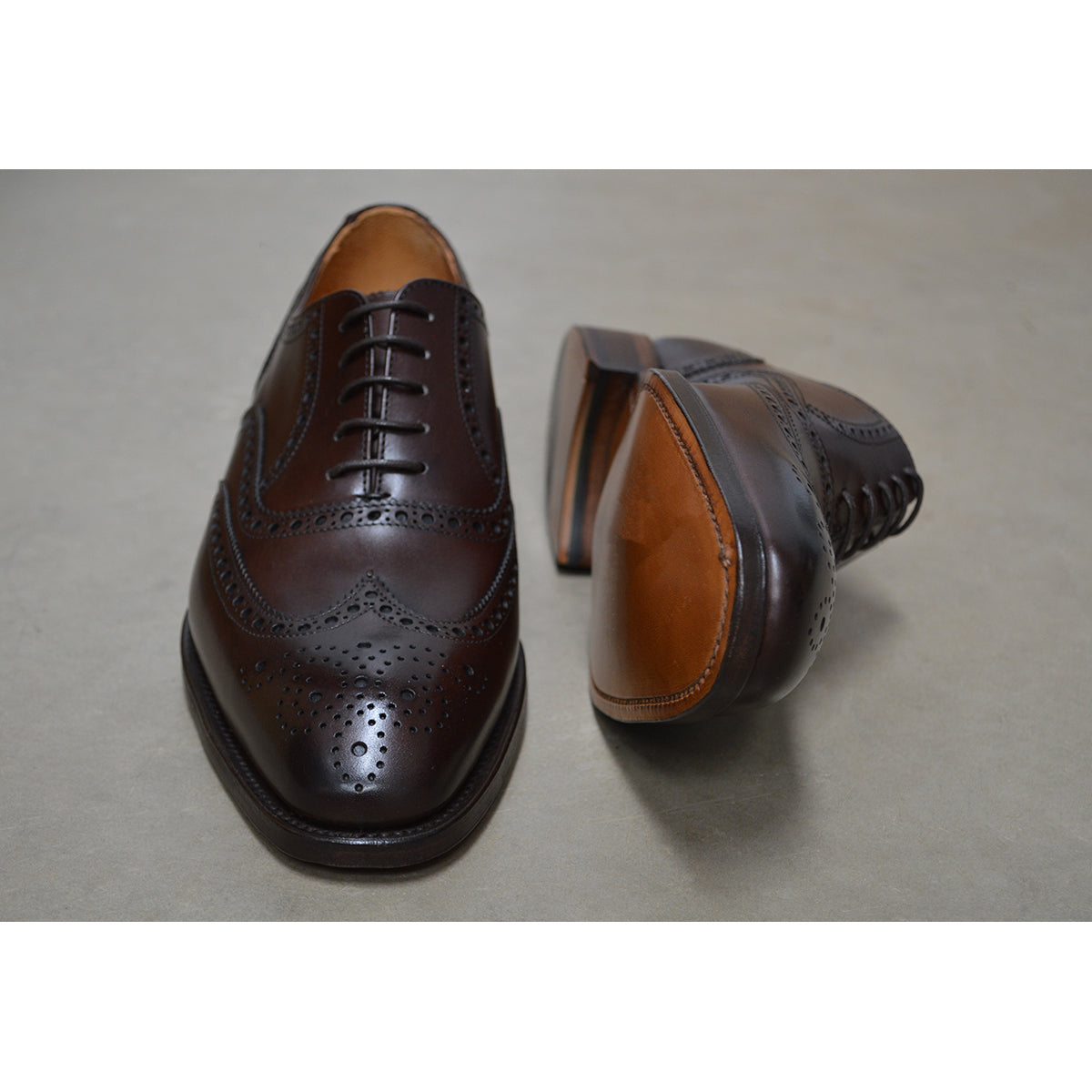 A dark brown Oxford brogue shoe with intricate brogue detailing and a goodyear welted leather sole.