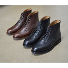 Berwick 1707 Black Kudu leather boot with laces and Vibram rubber sole on a polished concrete background