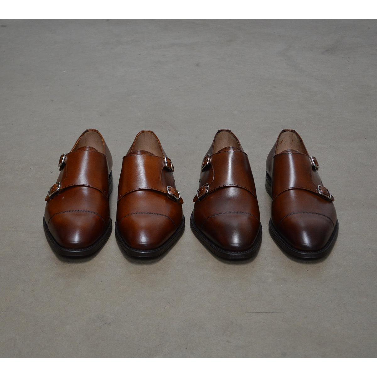A brown Berwick 1707 double monk shoe with double buckle monk strap on polished concrete