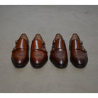 A brown Berwick 1707 double monk shoe with double buckle monk strap on polished concrete