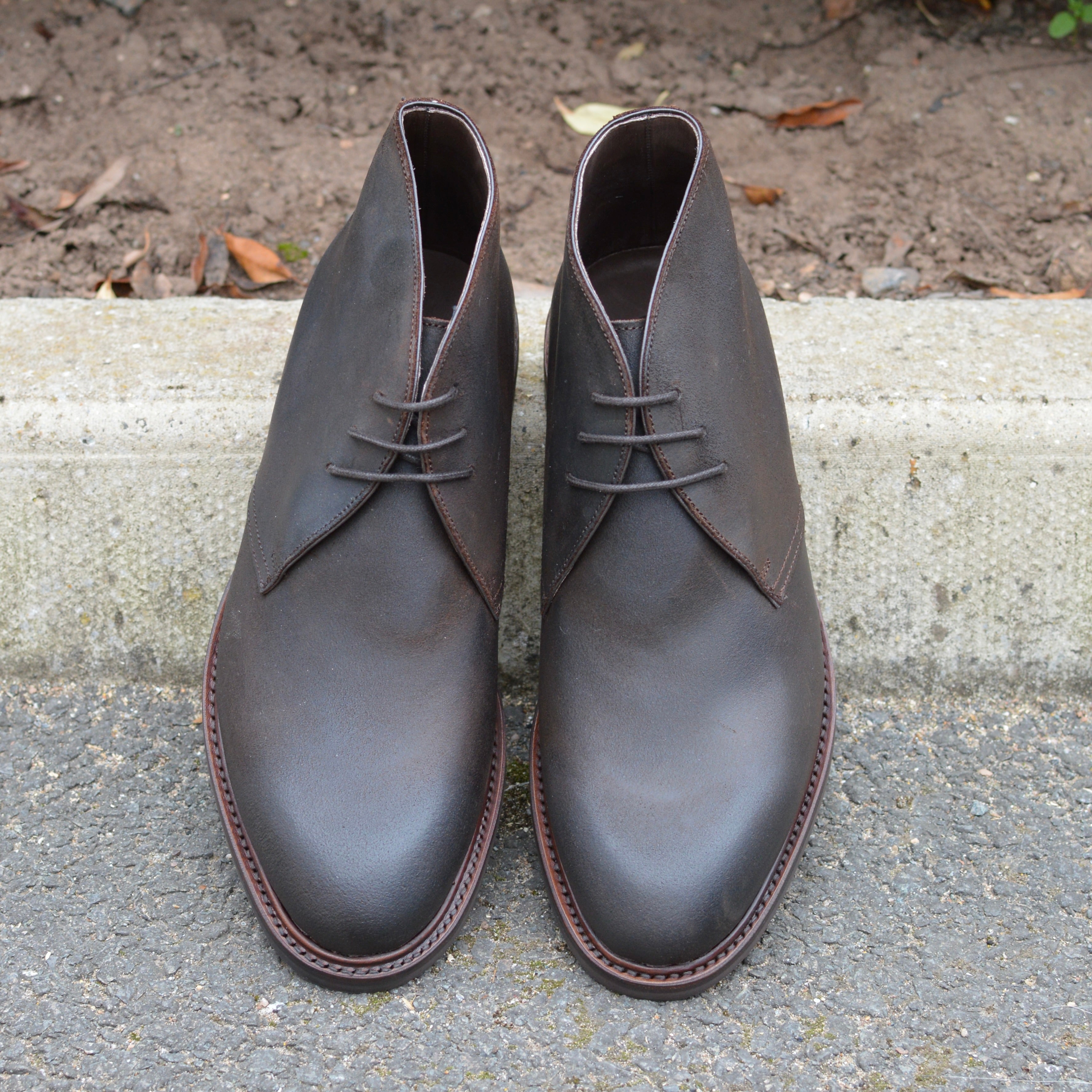 Berwick 1707 Waxy Brown leather chukka boot on a pavement edge background