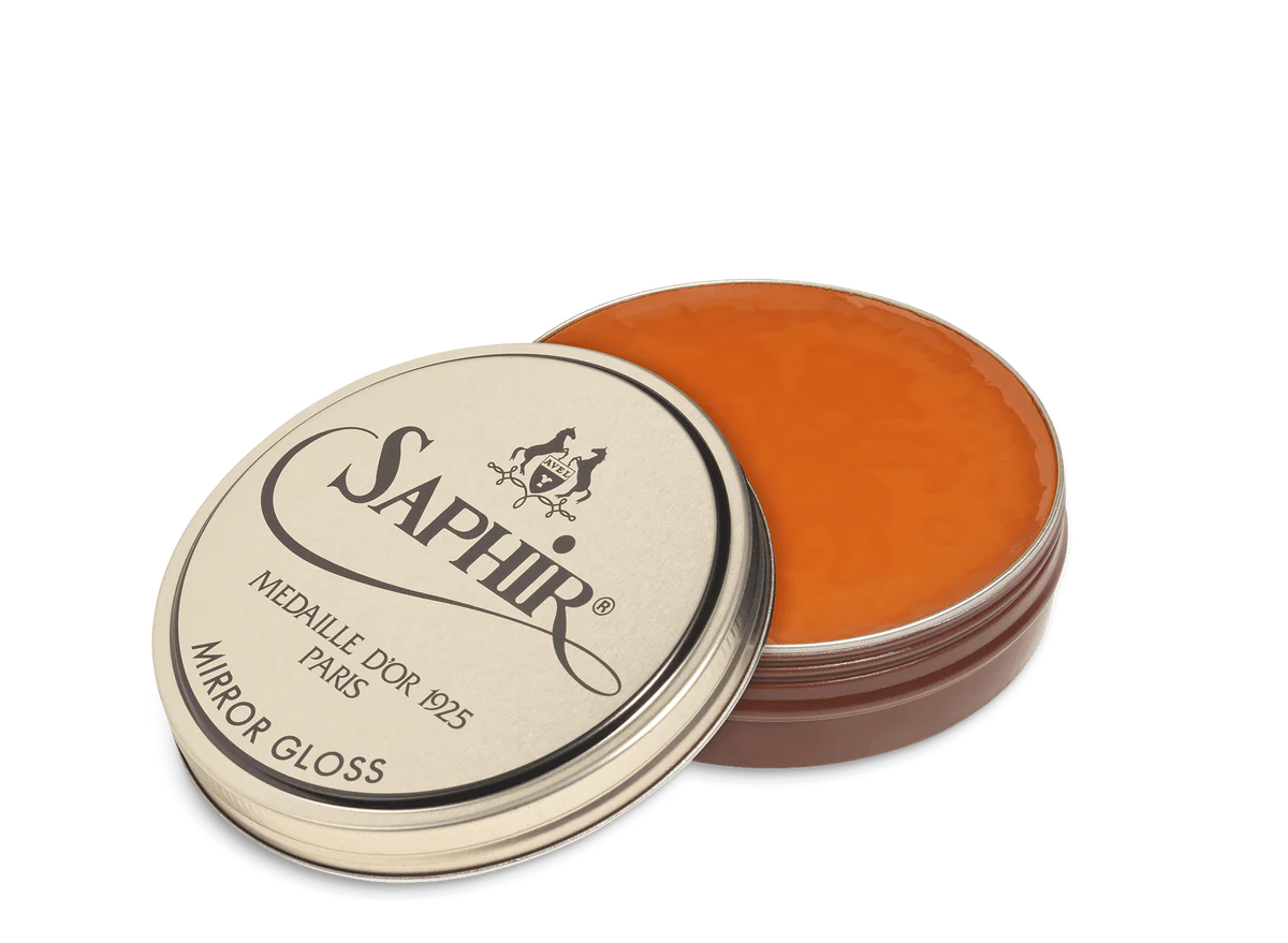 A tin of Saphir Medaille D'Or Mirror Gloss Wax Polish with the brand's logo and product name displayed on the lid.